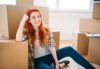 portrait-of-happy-woman-among-carton-boxes-housewarming-relocation-to-new-home@2x
